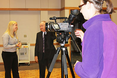 Photo of a student working a camera during an interview.